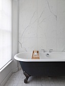 Bathtub in front of marble wall