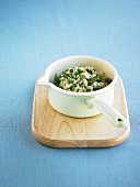 Green asparagus risotto in saucepan on wooden board