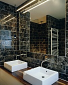 Bathroom with brown marble tiles, mirror and two sinks
