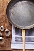 An empty frying pan on a wooden surface