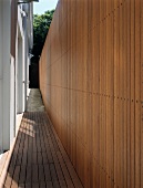 Mini-terrace and exit between house and high wooden wall