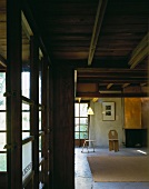 House with exposed wooden beam ceiling and minimalist living room furniture