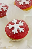 Cupcake mit roter Zuckerglasur und einer Schneeflocke