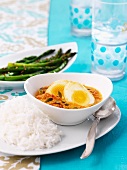 Egg curry with rice and green asparagus