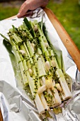 Leeks with thyme and garlic on aluminium foil (prepared for the barbecue)
