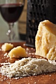 Grated Romano Cheese with Cheese Grater and Glass of Red Wine