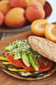 Veggie Sandwich with Grilled Eggplant, Zucchini, Yellow Peppers, Tomato and Avocado on a Flat Round Roll