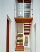 Modern, white stairwell with wooden stair treads