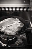 Sealing a T-bone steak in a frying pan