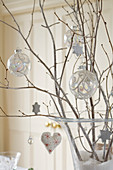 Christmas baubles and decorations hanging on twigs