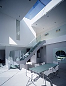 Open-plan, double-height dining area with stairs to upper storey