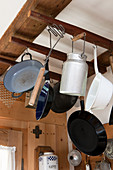 Vintage Kochgeschirr und Blech Milchkanne an Holzgestell unter der Decke aufgehängt