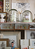 Tiny sculptures under bell jars and framed pictures on display cabinet