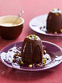 Baked chocolate pudding with pistachios and chocolate sauce