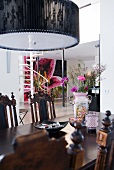 Englische Antikmöbel und moderne Hängelampe im Essbereich eines floral dekorierten Wohnhauses