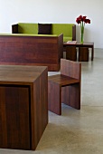 Tisch mit Stühlen und Holzrahmen vom Sofa aus gleichem dunklen Holz im Designerstil