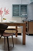 Holzstuhl aus Bauhauszeit vor modernem Küchentisch
