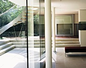 Minimalist living space with pillars in front of glass wall and view of courtyard