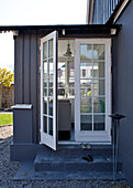 Open patio door with view of black and white sofa