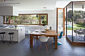 Modern kitchen and dining area with slate floor and glass wall leading to terrace