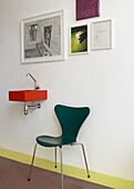 Wall-mounted washbasin, pictures and green chair