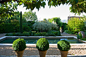 Symmetrisch angelegter Garten mit Wasserbecken und Buchsbaumkugeln