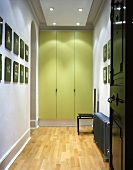 Hell beleuchteter modernisierter Flur mit Einbauschrank und grünlackierten Türen
