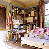 Wohnzimmer mit Bücherregalen, gemütlichem Sofa und klassischem Beistelltisch