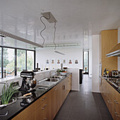 Kitchen with wooden cabinets, black worktop and pendant light