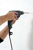 DIY - man drilling hole in wall