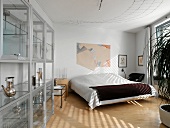 Bedroom with simple double bed and modern glass display case