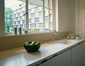 White kitchen unit with window & view of apartment building front
