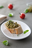 A slice of baguette with pesto genovese