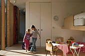 Two children playing in children's bedroom with play area & loft bed
