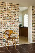 Retro wallpaper and wooden chair, view into kitchen