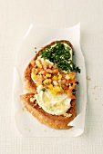 A slice of toasted bread topped with cream cheese, vegetable tatar and chives