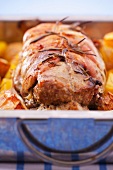 Turkey roulade with rosemary, vegetables and fruit in a roasting tin