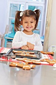 A little girl in front of a tray of gingerbread men