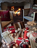 Presents tied with ribbons on bench in front of rustic armchairs and open fire