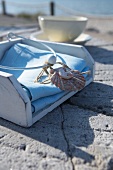 White napkin holder decorated with a shell on a limestone surface