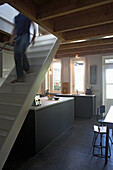 Kitchen with dark cupboards under stairs