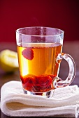 A glass of jasmine tea with raspberries