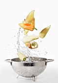 Hungarian peppers with a water splash and a colander
