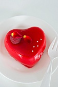 A heart-shaped rose pudding decorated with a raspberry