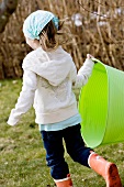 Girl walking in garden holding green basket