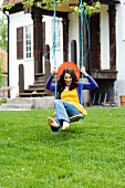 Young woman on swing in garden