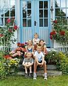 Five children sitting on front step of house