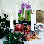 Advent wreath decorated with four burning candles, red onions and cinnamon sticks