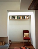 Red upholstered chair in niche next to open fireplace