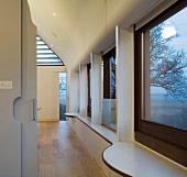 Long wall of windows with curved windowsills in modern, open-plan house